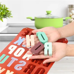 Dettaglio stampo in silicone a 26 lettere con saponi a forma di lettera colorati in mano