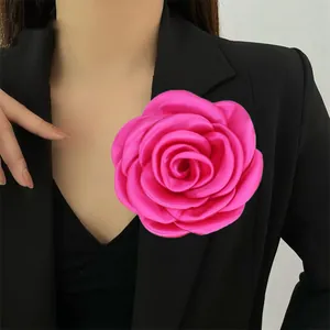 Dettaglio di una grande spilla a rosa fucsia fatta a mano su un blazer nero elegante