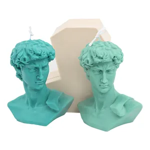 Teal David bust candles shown next to the beige silicone mold on a white background.