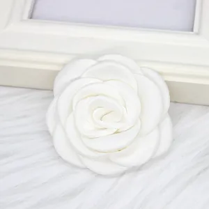 Nahaufnahme einer weißen handgefertigten Kamelien-Stoffblume als Brosche und Accessoire