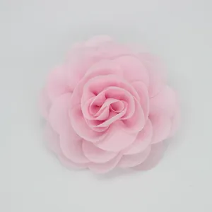 Vista macro detallada de una flor de rosa de tela de gasa rosa claro con múltiples capas