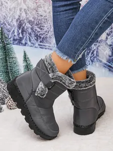 Close-up detail of grey waterproof women snow boots with warm faux fur lining and strap.