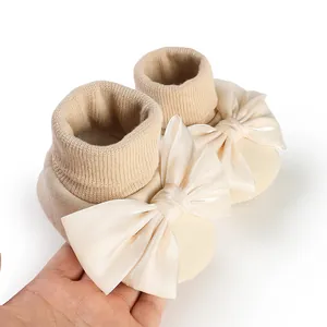 Detailed view of cream baby anti-slip floor socks featuring a large satin bowknot decoration