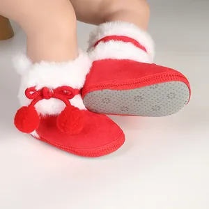 Close-up detail of red baby winter boots with white faux fur trim and anti-slip floral soles