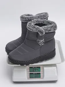 Detailed macro view of grey waterproof snow boots weighing 0.44kg on a digital scale