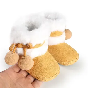 Close-up of cozy yellow baby boots featuring white faux fur lining and pom-poms