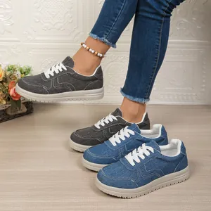 Detail van comfortabele denim sneakers voor dames in grijs en blauw met zachte zolen.