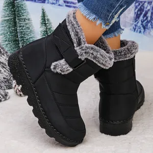 Close-up of black waterproof women's snow boots with grey faux fur lining and velcro