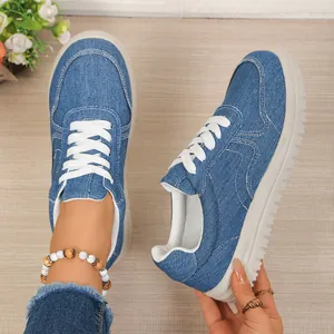 Gedetailleerde close-up van de blauwe denim sneakers voor dames met zachte witte zolen