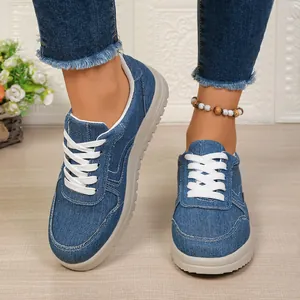 Detailopname van blauwe denim dames sneakers met witte katoenen veters voor dames.
