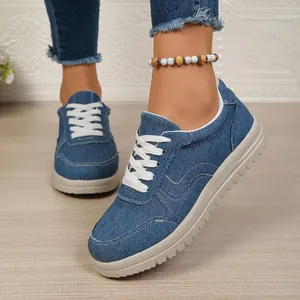 Detailopname van blauwe denim casual damessneakers met witte veters en comfortabele zachte zool