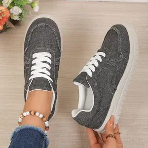 Gedetailleerd overzicht van donkergrijze canvas sneakers met een zachte witte zool voor dames