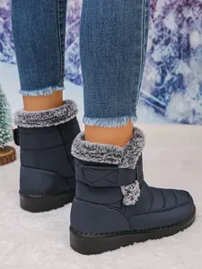 Detailed view of navy blue winter snow boots with grey faux fur lining and velcro strap