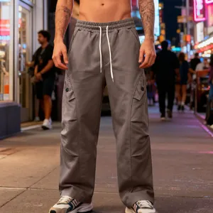 Detail view of grey wide-leg cargo sweatpants with drawstring and side flap pockets