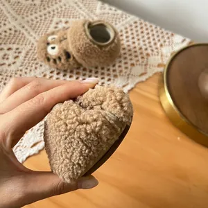 Close-up showing the soft and flexible sole of these brown fleece-lined baby shoes