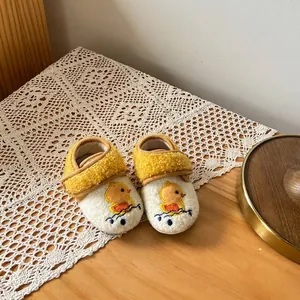 Close-up of warm fleece baby pre-walker shoes with cute yellow duck embroidery