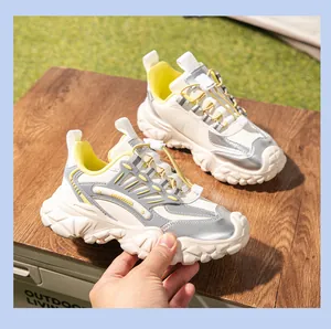 Primer plano de zapatillas outdoor de cuero genuino para mujer en plateado y amarillo.