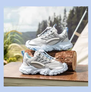 Zapatillas deportivas plateadas y azul claro para mujer sobre un tronco de madera