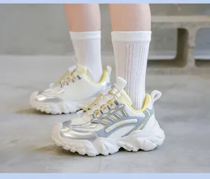 Detalle de zapatillas chunky blancas con detalles plateados y bordes amarillos.