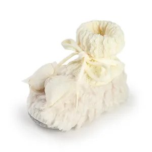 Macro detail view of soft and warm fleece-lined baby winter shoes with a cute bow tie