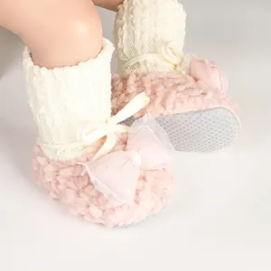 Detailed view of pink fuzzy baby shoes featuring a mesh bow and knit socks for infants