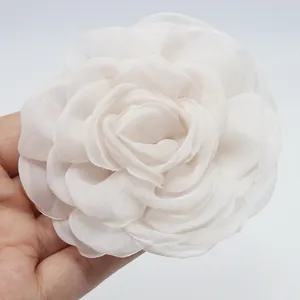 Primer plano de un broche de camelia en organza blanca de 8 cm con elegantes bordes