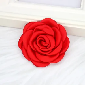 Makro-Detail einer 6 cm großen roten handgefertigten Satinrose für Kleidung und Haar.