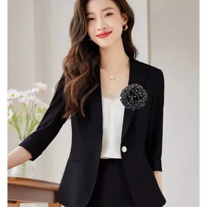 Elegant French style black polka dot rose corsage detail on a classic black blazer jacket