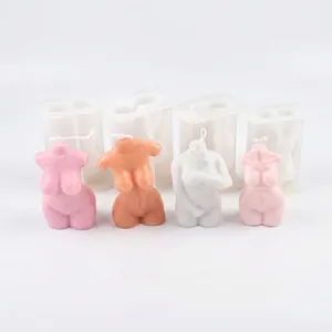 Close-up of four colored female torso candles placed in front of translucent molds