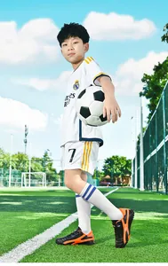 Gros plan de chaussures de football professionnelles pour enfants sur un terrain de gazon