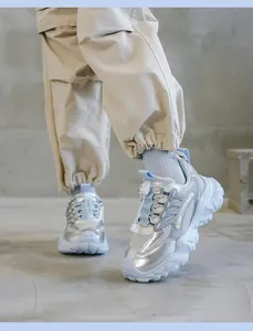 Vista detallada de zapatillas chunky de cuero plateado y azul con pantalón cargo.