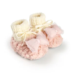 Detail of pink fluffy baby shoes with large bows and fleece lining for newborns