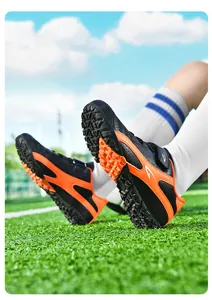 Gros plan de chaussures de football pour enfants montrant la semelle orange et le scratch