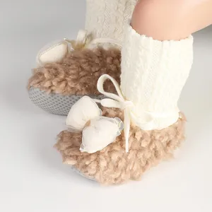 Detailed close-up of warm fuzzy baby winter socks shoes with bow and white knit cuff