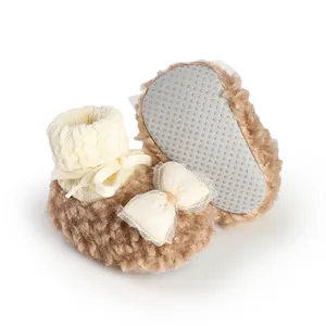 Detail of cozy fleece-lined winter baby booties with non-slip dotted sole and cute bow