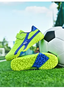 Gros plan de chaussures de football pour enfants vertes avec semelle à crampons