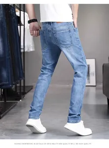Rear view of slim fit light blue men's stretch denim jeans showing back pocket details