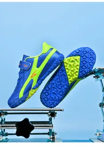 Vue détaillée des chaussures de football extérieur bleu et vert pour enfants à crampons.