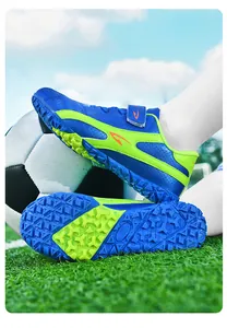 Gros plan de chaussures de football pour enfants bleues et vertes avec crampons
