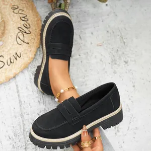 Close-up detail of black matte platform loafers with thick soles and slip-on design