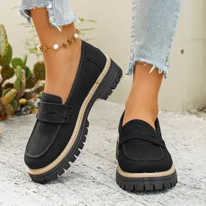 Detail of vintage black matte loafers with chunky platform sole and contrast stitching.