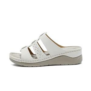 Elegant white wedge sandals for women featuring laser-cut straps and stylish stitching.