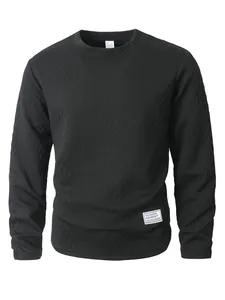 Detail of black textured long sleeve sweatshirt with waffle knit and decorative patch