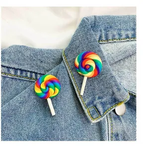 Close-up detail of cute rainbow lollipop brooches pinned on a blue denim jacket