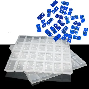 Detailed macro view of translucent domino silicone mold with finished blue resin pieces.