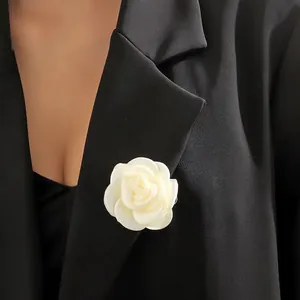Detailansicht einer handgefertigten 6 cm weißen Kamelienblüten-Brosche an einem schwarzen Blazer.