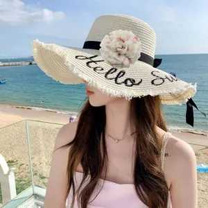 Primo piano di un grande fiore di peonia in tessuto su un cappello di paglia estivo