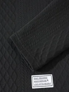 Close-up detail of black diamond textured fabric with a white woven slogan patch.