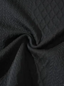 Close-up detail of black diamond-textured knit fabric for a casual pullover sweater