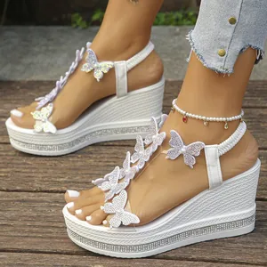 Detailed view of white butterfly wedge sandals with rhinestone platform sole